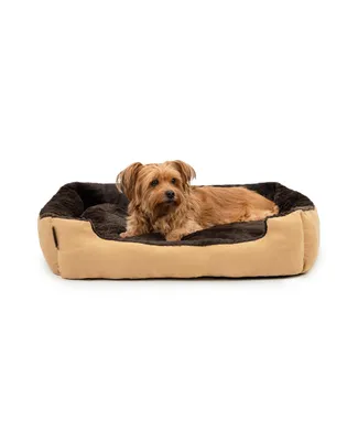 A small dog is lying on a dog bed.