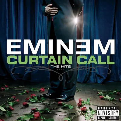 Eminem standing on a stage with roses scattered on the floor.