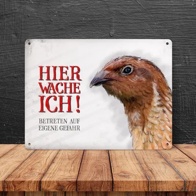 A metal sign with a quail image and text is displayed on a wooden surface against a dark background.