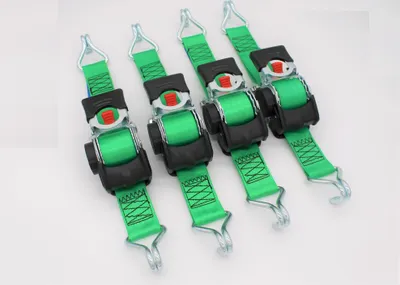 Four green ratchet straps with black buckles and silver hooks are laid out diagonally on a white background.