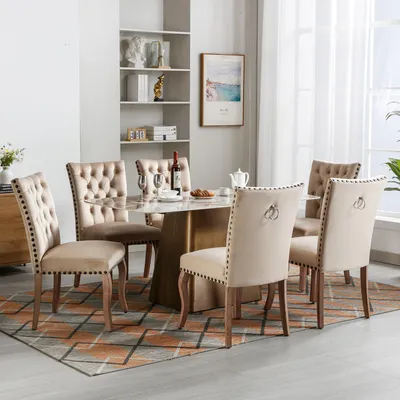A dining room set with a marble-top table and six beige upholstered chairs.