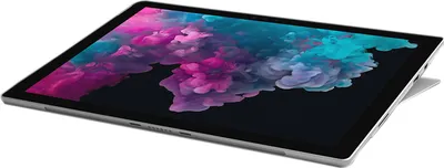 A silver Microsoft Surface Pro 6 tablet is shown at an angle against a white background. The screen displays a colorful abstract image.
