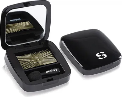 A black eyeshadow compact with a gold eyeshadow and applicator is shown open, with the lid placed next to it.