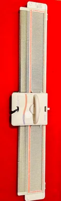 A knitting machine is shown against a red background.