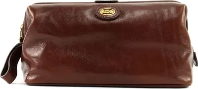A brown leather toiletry bag with a gold logo on a white background.