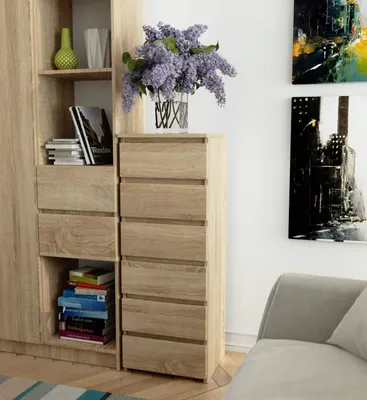 A chest of drawers with books and a vase of flowers.