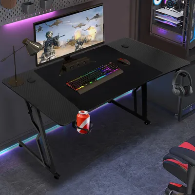 A gaming desk setup with a computer, monitor, keyboard, and accessories.