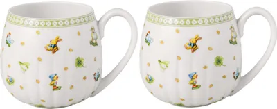 Two white ceramic mugs with a decorative pattern of bunnies and clovers.