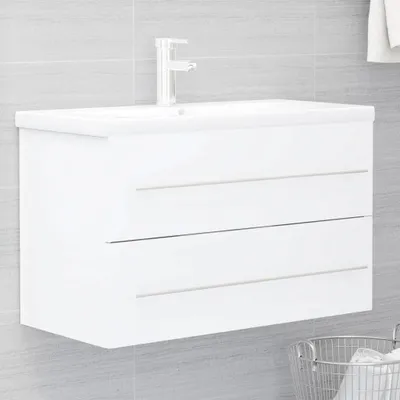 A white bathroom vanity with a faucet mounted on top, set against a tiled wall.