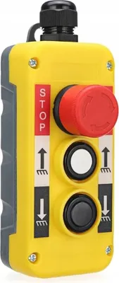A yellow and gray industrial control pendant with red, white, and black buttons and labels.