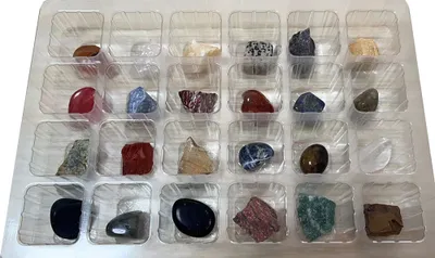 A collection of natural minerals and gemstones arranged in a clear plastic tray, likely an advent calendar.