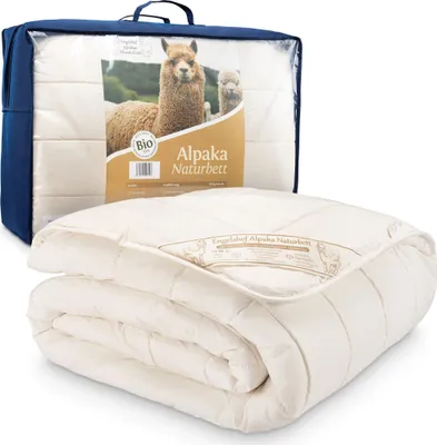 A folded duvet is shown in front of its packaging, which features an image of alpacas and product information.