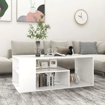 A white coffee table is placed in a living room setting with a sofa in the background.