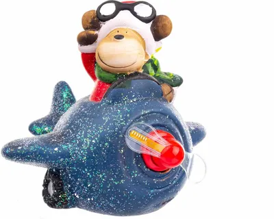 A close-up of a Christmas ornament featuring a monkey dressed as a pilot riding in a blue airplane.