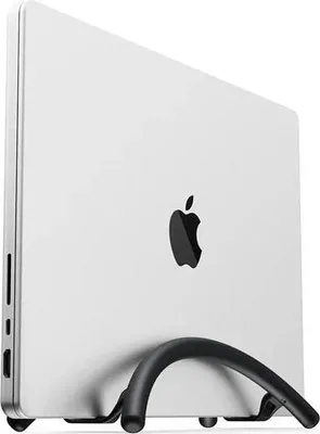 A white MacBook is shown in a vertical stand.