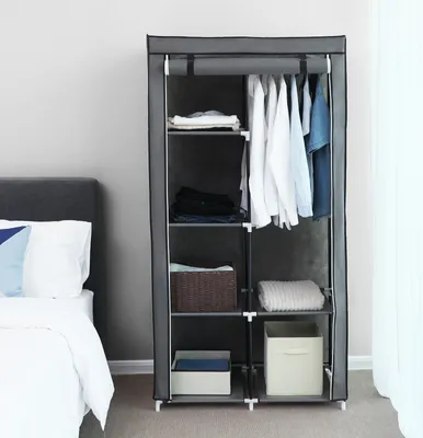 A portable wardrobe is shown next to a bed in a room.