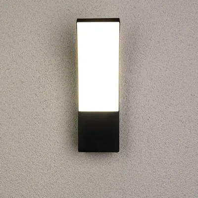 A black and white rectangular outdoor wall light mounted on a textured gray wall.
