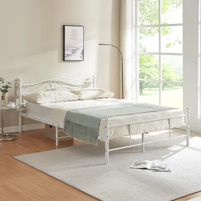 A bedroom scene with a white metal bed frame.