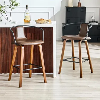 Image de Ensemble de 2 tabourets de bar avec accoudoirs – Tabourets de bar scandinaves en similicuirPolyuréthaneavec pieds en bois et repose-pieds en métal, siège rembourré avec dossier, idéaux pour une îlot de cuisine, un bar, une salle à manger – Couleur : marron