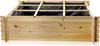 A wooden raised garden bed with a black liner and wooden support beams across the top.