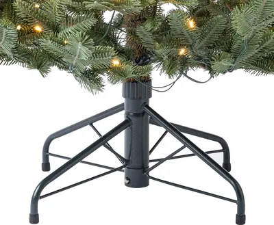 The base and lower branches of an artificial Christmas tree with lights.