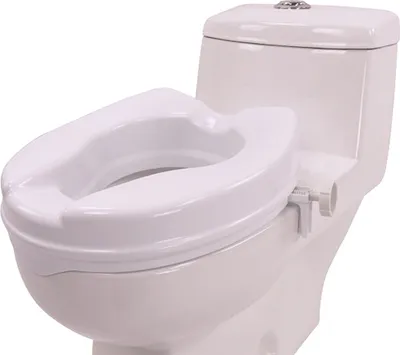 A white toilet seat riser is attached to a white toilet.