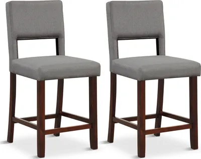 Two gray upholstered bar stools with dark wooden legs are shown against a white background.