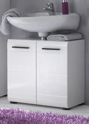 A white bathroom vanity with a sink and a purple object on top, placed on a purple rug.