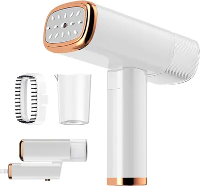 A white and gold handheld garment steamer with accessories, photographed against a white background.