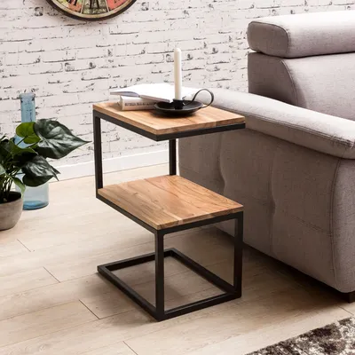 A side table with a wooden top and metal frame placed next to a sofa in a living room.