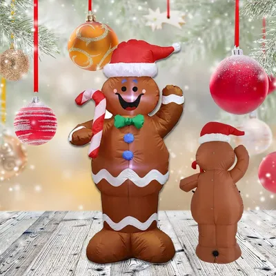 Two inflatable gingerbread figures, one large and one small, are displayed outdoors with Christmas ornaments hanging in the background.