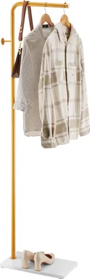 A clothing rack with two shirts and a handbag hanging on it, and a pair of shoes on the base.