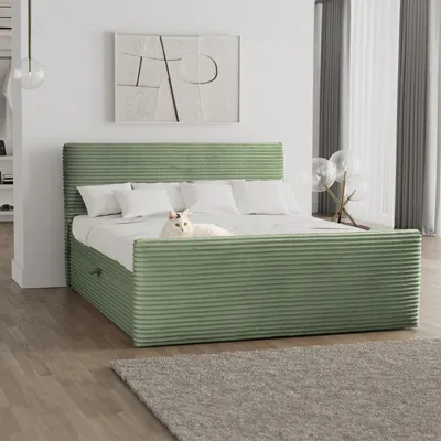 A bedroom scene featuring a green upholstered bed with white bedding and pillows. A white cat is lying on the bed.
