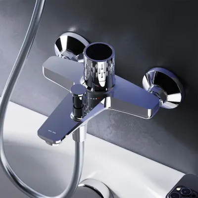 A close-up view of a chrome bathtub faucet mounted on a wall above a white bathtub.