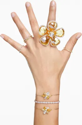 A hand adorned with multiple rings and bracelets, showcasing jewelry.