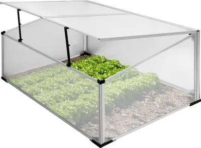 A greenhouse with plants growing inside, with the lid open.