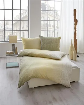 A bedroom scene with a bed, nightstand, and large windows.