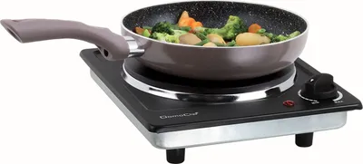 A portable electric stovetop with a pan of vegetables cooking on it.