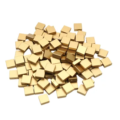 A pile of small, square, gold-colored tiles.