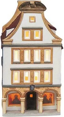 A decorative ceramic house, likely a Christmas village piece, with illuminated windows.