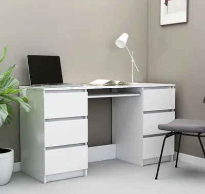A white desk with drawers, a laptop, and a book.