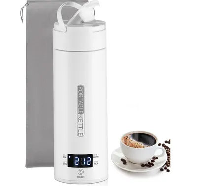 A white portable kettle with a digital display and a cup of coffee next to it.