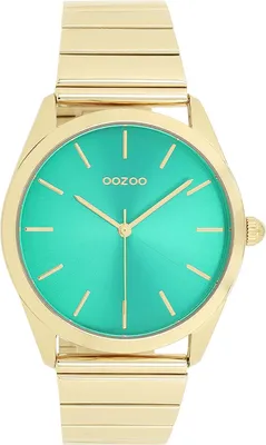 A close-up studio shot of a gold wristwatch with a green face.
