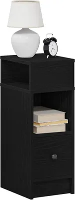A black nightstand with a drawer and an open shelf, topped with a white lamp and a black alarm clock.