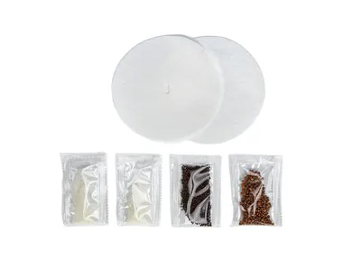 A set of accessories for sprouting seeds, including two white filters and four small sealed packets containing different types of seeds.