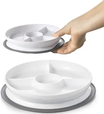 A hand is shown placing a divided plate with a suction base onto a surface.