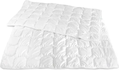 A white duvet is folded and laid out on a white background.