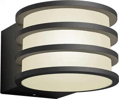A modern, cylindrical wall lantern with multiple stacked rings, mounted on a dark rectangular base.