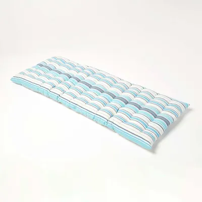 A long, striped cushion lying on a white surface.