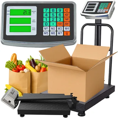 A digital scale with a platform, a display unit, and a cardboard box with groceries in paper bags.